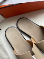 Sandali slip-on beige e neri, design moderno, comfort e stile per look casual eleganti.