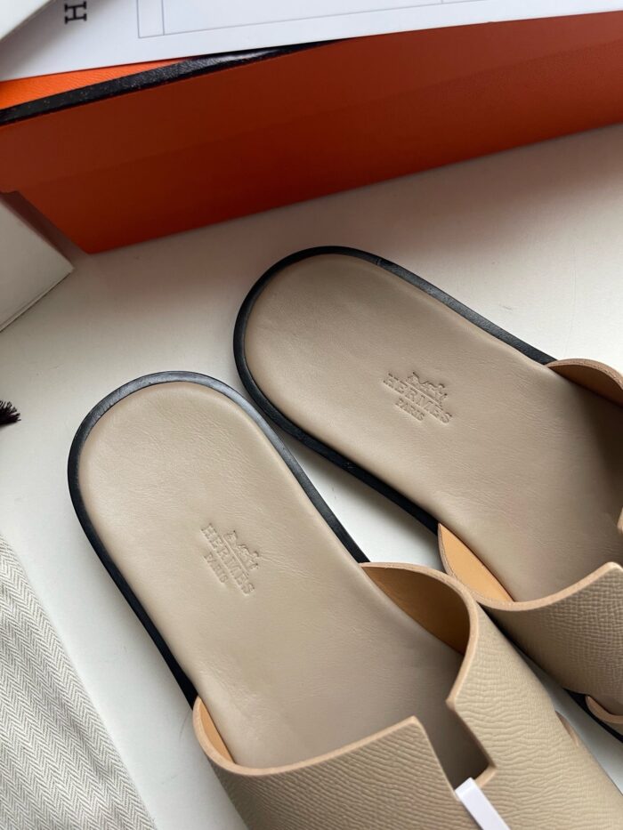 Sandali slip-on beige e neri, design moderno, comfort e stile per look casual eleganti.