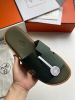 Sandalo verde minimalista con suola color Natale, dettagli eleganti e confezione raffinata.