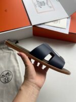 Sandali navy di lusso con dettagli moderni, packaging premium e design elegante per lestate.