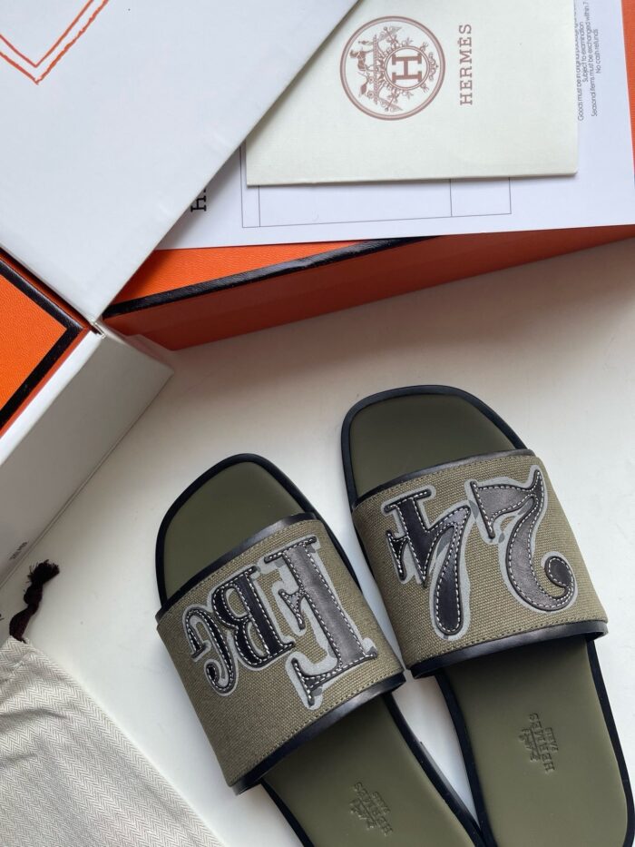 Sandali di lusso con design elegante, logo prominente e packaging raffinato, perfetti per stile e comfort.