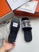 Infradito nero e grigio con packaging premium e dettagli di stile e comfort.