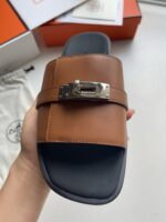 Sandali slides in pelle marrone con fibbia metallica, eleganti e comodi per ogni occasione.
