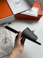 Sandali neri di lusso minimalisti con packaging elegante e dettagli di alta qualità.