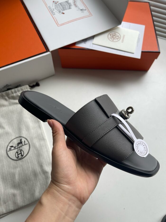 Sandali di lusso in pelle con charm brandizzato, eleganti e comodi per l’estate.