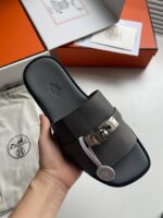 Sandalo di alta moda con cinturino in metallo e design elegante, packaging di lusso.