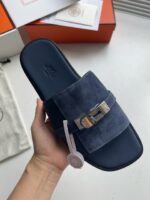 Sandalo navy in suede con fibbia metallica e suola piatta elegante e confortevole.