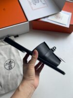 Sandalo nero di lusso con packaging elegante, dettagli raffinati e materiale di alta qualità.