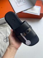 Sandalo nero di lusso con fibbia e packaging elegante, perfetto per stile e comfort sofisticato.