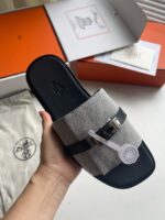 Sandalo slide in tessuto grigio e nero con fibbia, perfetto per look casual e sofisticati.