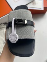 Sandalo uomo elegante con cinturino in metallo, tessuto grigio e dettaglio raffinato.