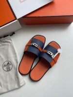 Sandali slide eleganti navy e arancione con fibbia metallic, comfort e stile raffinato.
