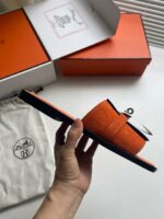 Sandali arancioni di design con dettagli eleganti, packaging di lusso e stile trendy.