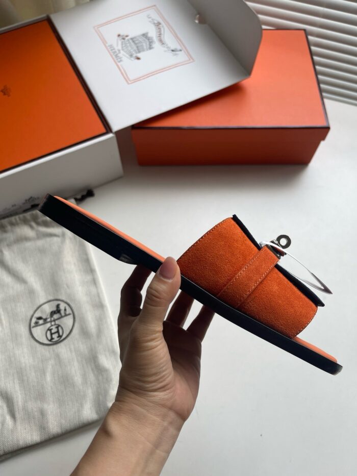 Sandali arancioni di design con dettagli eleganti, packaging di lusso e stile trendy.