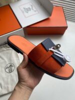 Sandali di lusso arancioni e navy con dettaglio elegante, perfetti per uno stile sofisticato.