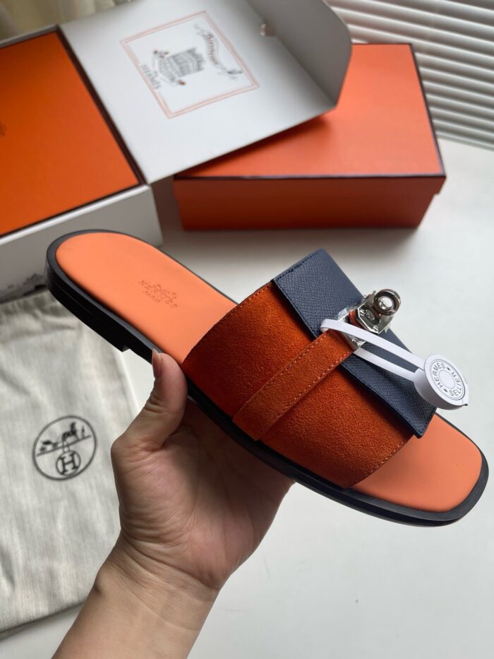 Sandali di lusso arancioni e navy con dettaglio elegante, perfetti per uno stile sofisticato.