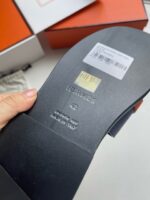 Scarpe Hermès di lusso con suola brandizzata e packaging arancione elegante.