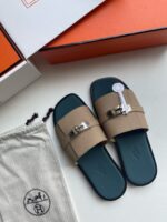 Sandali di lusso in suede con fibbia oro, suola blu e confezione elegante.