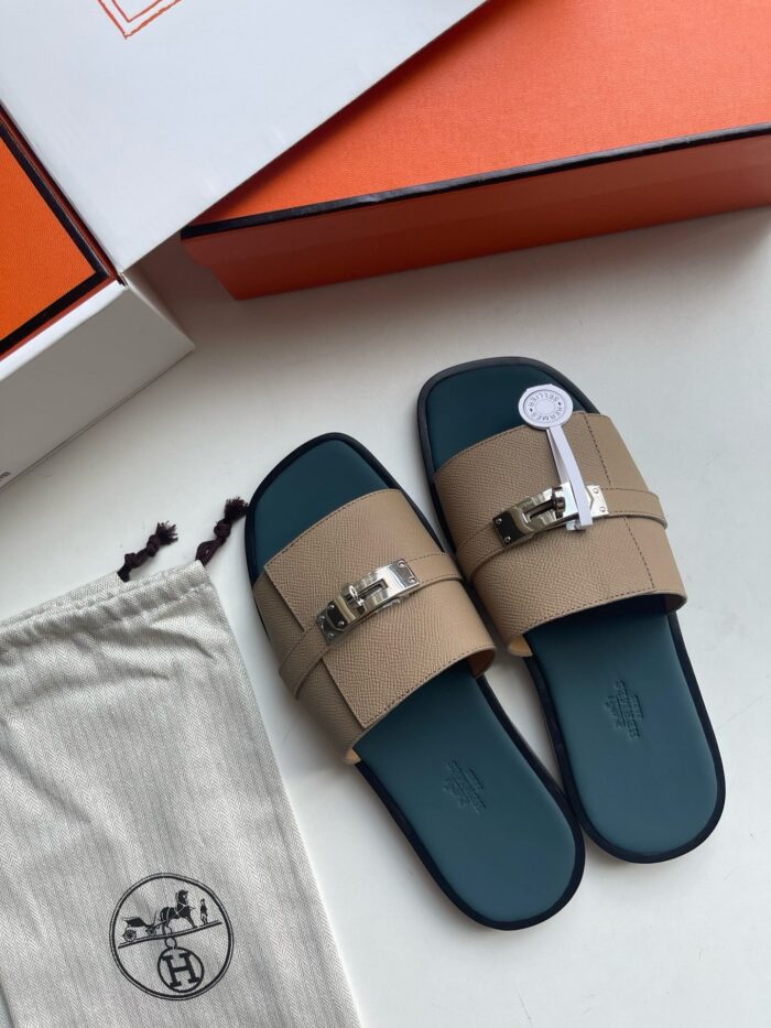 Sandali di lusso in suede con fibbia oro, suola blu e confezione elegante.