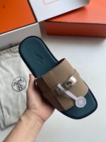 Sandalo slip-on di lusso beige con sole teal, dettaglio metallico e packaging elegante