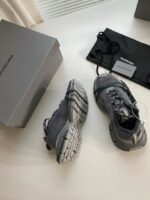 Sneaker grigia moderna e elegante con packaging minimalista e accessorio portaoggetti stiloso.