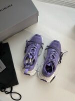 Sneakers sportive viola con scatola di lusso e borsa elegante, stile moderno e raffinato.