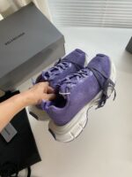 Sneakers Balenciaga viola con scatola di lusso, design moderno e stile elegante in luce naturale.