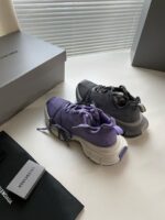 Sneaker alla moda viola e grigia in ambiente minimalista, perfette per stile e comfort.
