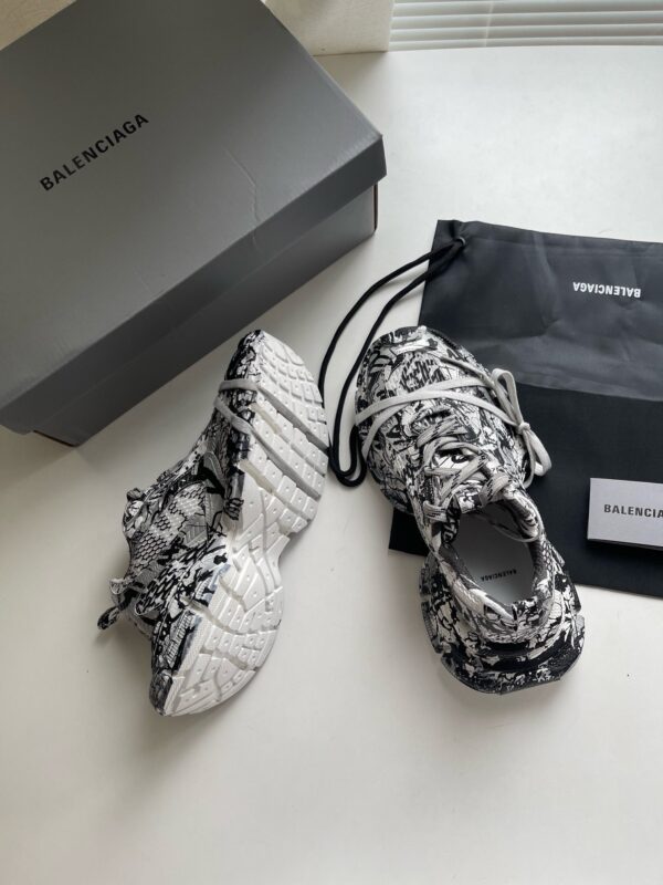 Scarpe Balenciaga moderne con packaging minimalista e design artistico in bianco e nero.