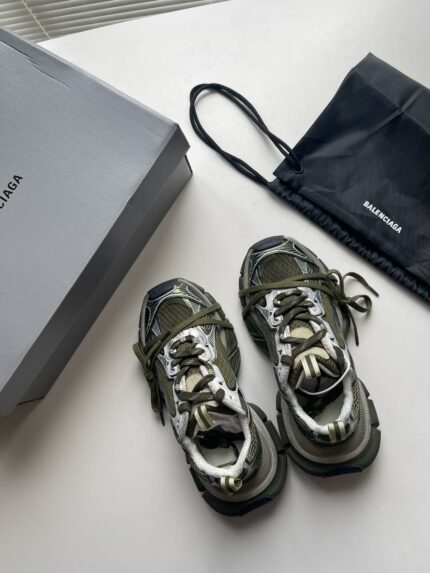 Sneakers moderne e di lusso con scatola minimal, borsa nera e design sofisticato.