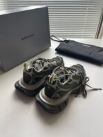 Scarpe Balenciaga in verde e grigio con packaging di lusso e custodia elegante.