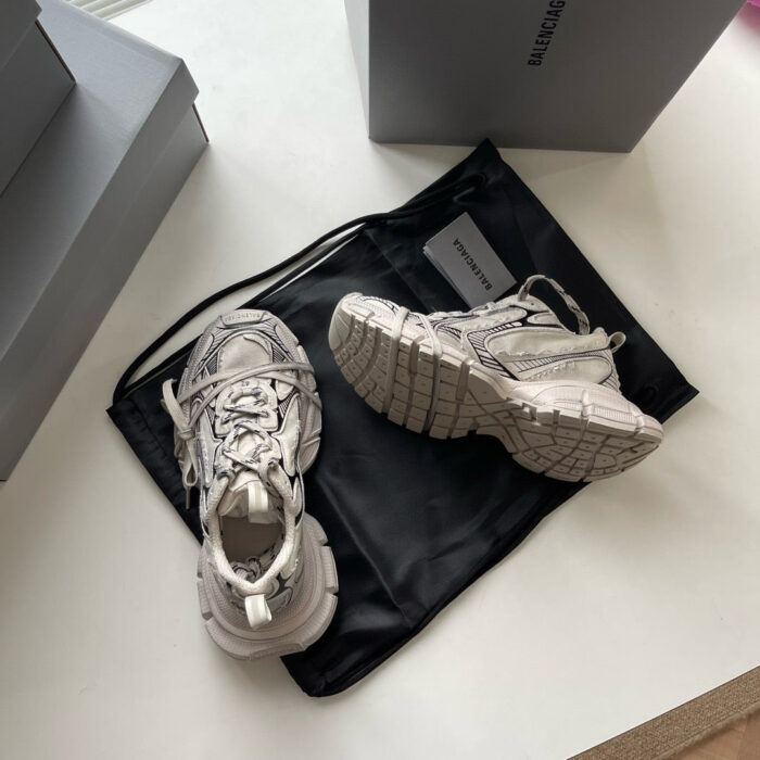 Sneakers moderne bianche con dettagli eleganti su borsa nera, stile casual e di tendenza.