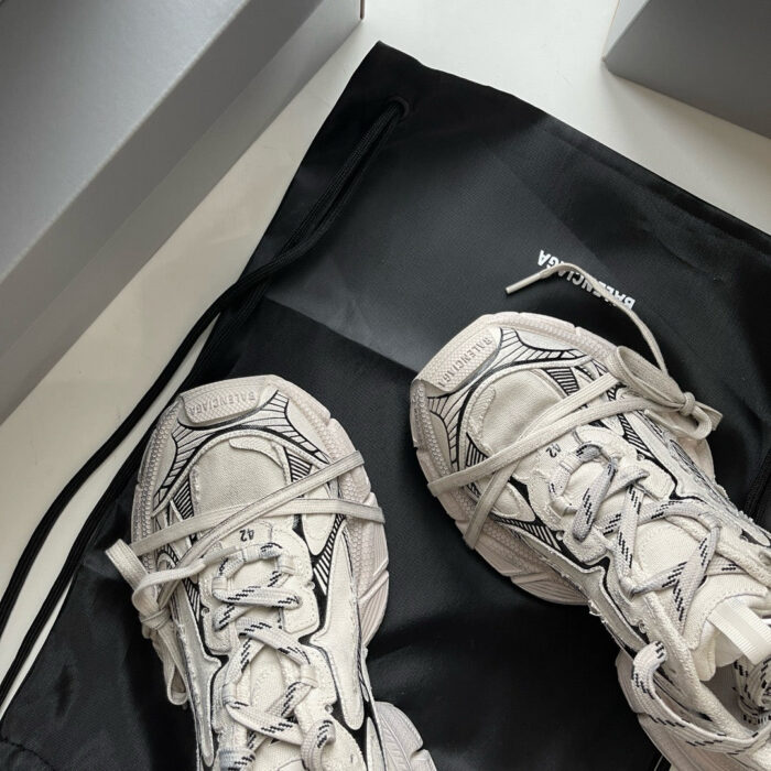 Scarpe sportive moderne bianche su borsa nera elegante, stile minimalista e design di lusso.