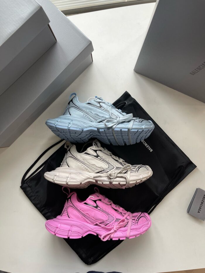 Collezione di sneakers moderne con colori vari, su sacchetto nero e scatole grigie, stile urbano.