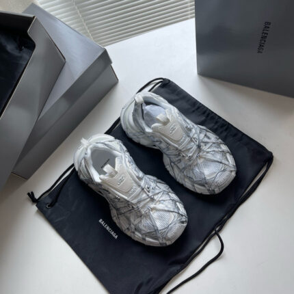 Sneakers di lusso futuristiche su dust bag nero, con scatole minimaliste grigie eleganti.