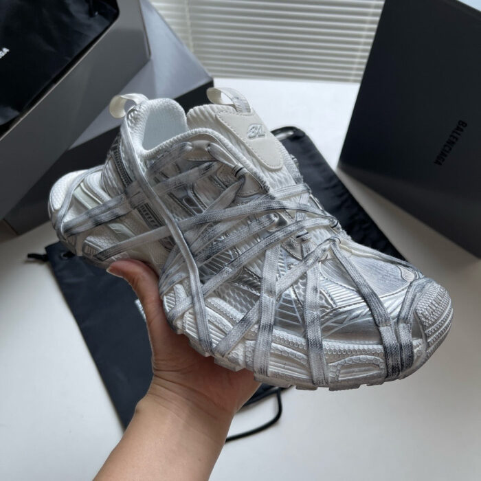 Sneaker futuristica bianca e grigia con design moderno e dettagli innovativi.