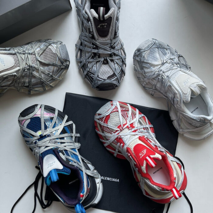 Sneaker moderne con design innovativi, dettagli elaborati e tonalità monocromatiche con accenti rossi vibranti.