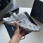 Sneaker bianca moderna con design traforato e dettagli innovativi, originale e di tendenza.