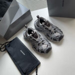 Sneakers moderne in grigio con pouch nero e scatole eleganti, stile chic e casual.