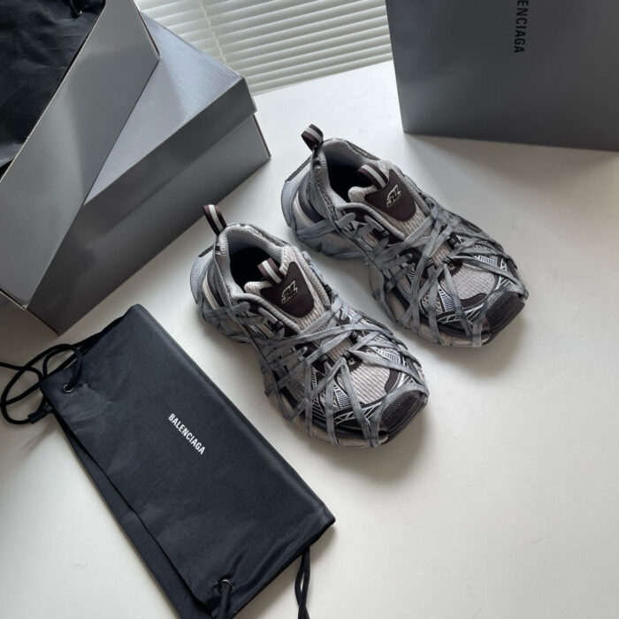 Sneakers moderne in grigio con pouch nero e scatole eleganti, stile chic e casual.