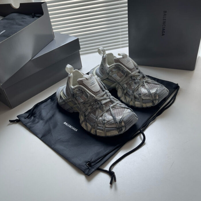 Sneakers moderne in mesh grigio con packaging minimalista e design elegante, perfette per uno stile urbano.