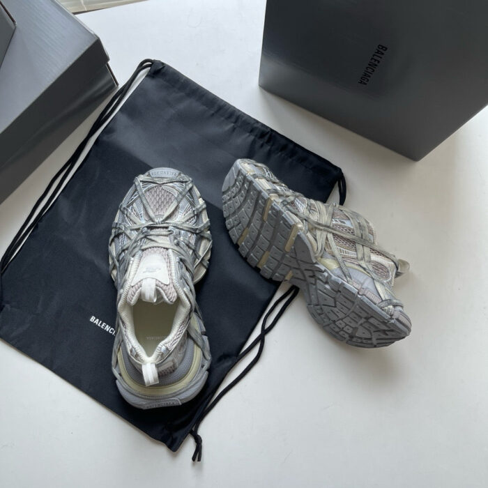 Sneakers moderne grigie con dettagli texturizzati e accessorio elegante, ideali per stile e comfort sportivo.