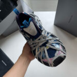 Sneaker sportiva moderna blu, rosa e grigia con design innovativo e dettagli respiranti.
