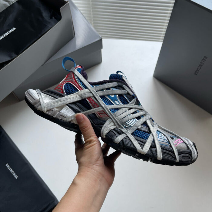 Sneaker innovativa di design premium con fasce elastiche, colori grigi, blu e rossi, stile moderno.