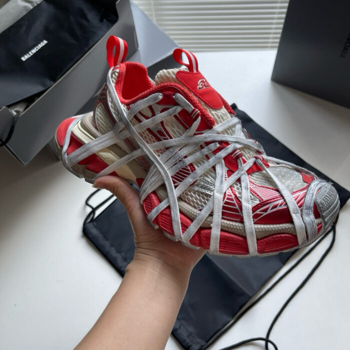 Scarpe sportive futuristiche rosse e bianche con design innovativo e struttura web, nuove e di tendenza.