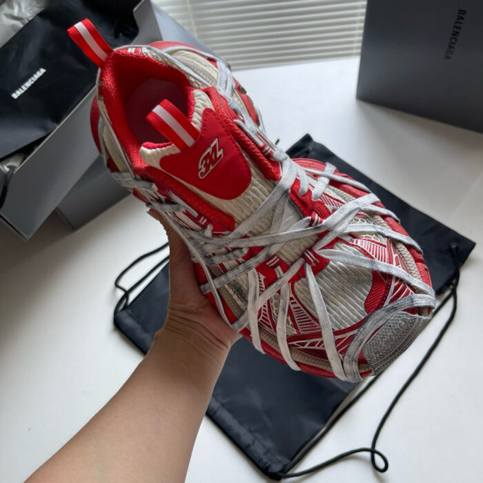 Sneaker sportiva rossa e bianca con design moderno e dettagli innovativi.