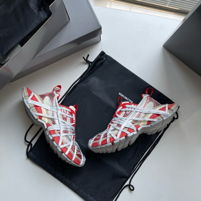 Sneakers rosse e bianche, elegante borsa nera, packaging premium, stile sportivo e moderno.