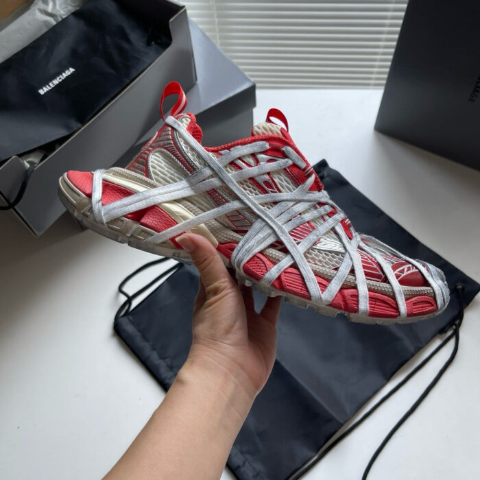 Scarpe sportive rosse con design moderno, suola trasparente e lacci stilizzati, in confezione premium.