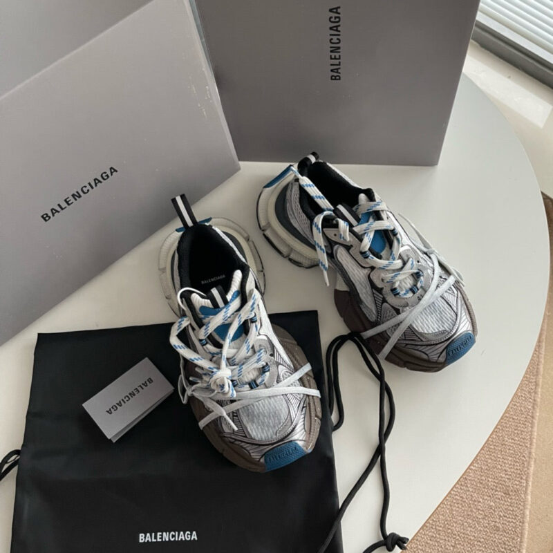 Sneakers Balenciaga di lusso con packaging minimalista e dust bag in ambiente elegante.