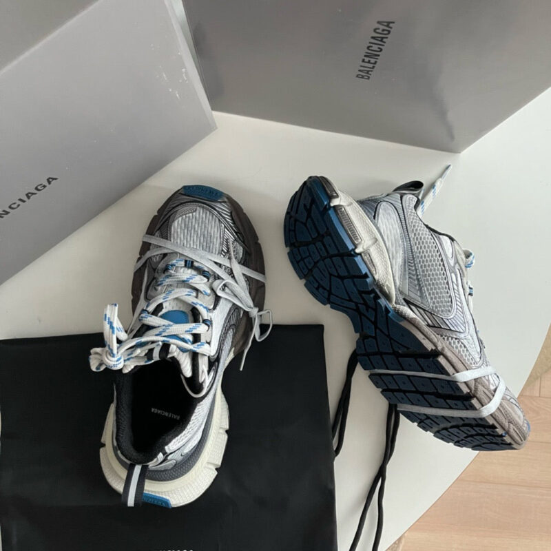 Sneakers Balenciaga di lusso con dettagli moderni e shopping bag elegante.